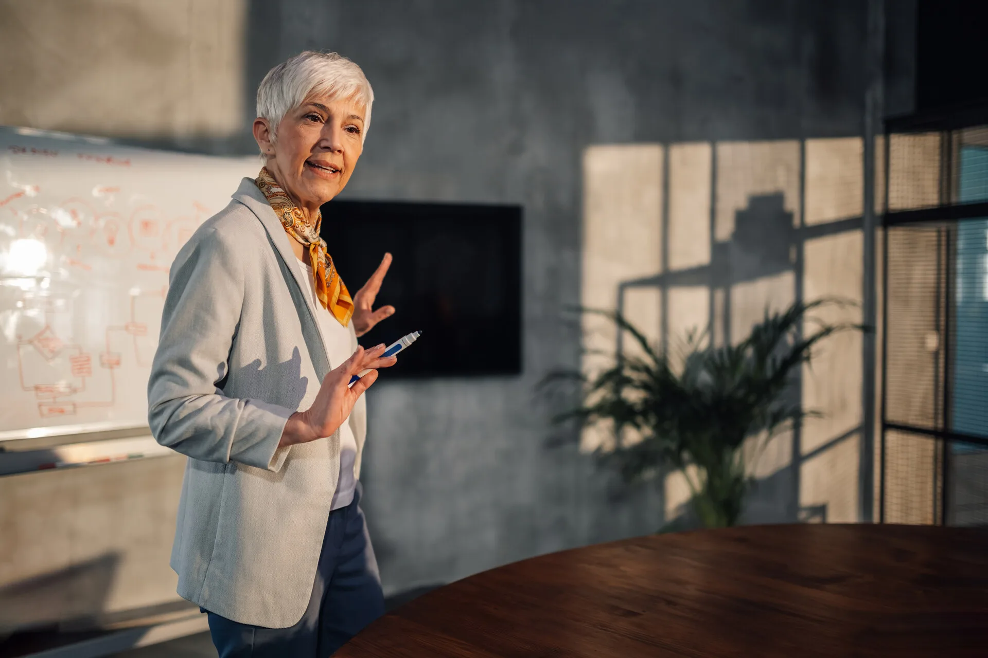 A senior professional presenting a business strategy in a workplace meeting